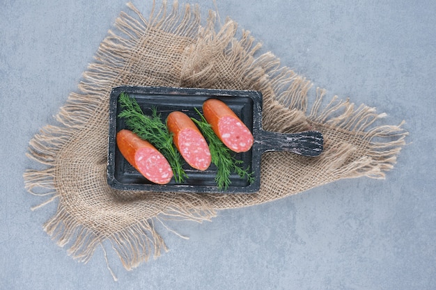 Free photo salami slices on the black cutting board .