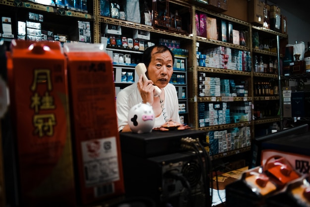 Free Photo sales clerk in small taiwan shop talking on the phone