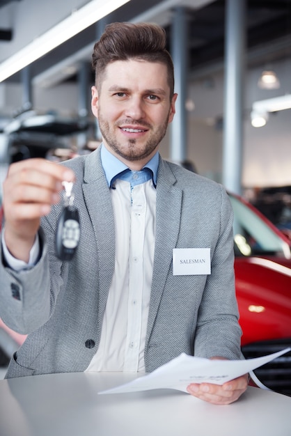 Free photo salesman with car keys in front of the camera