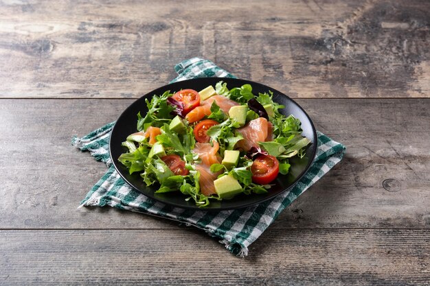 Salmon and avocado salad on rustic wooden table