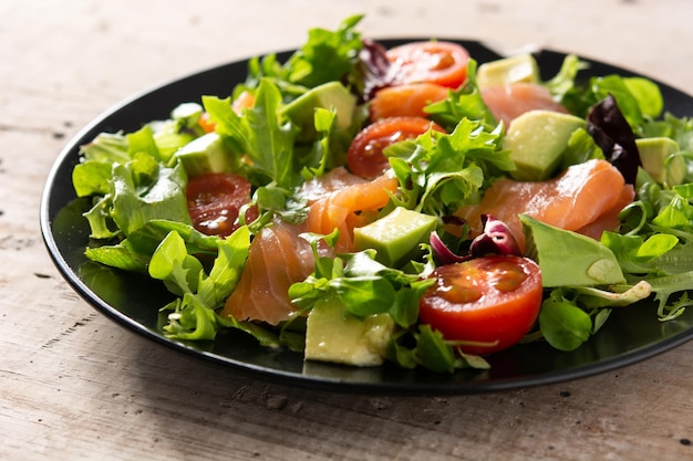 Free photo salmon and avocado salad on rustic wooden table