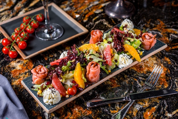 Salmon salad with lettuce, tomatoes, corn, orange, grapefruit, pomegranate and cream 1