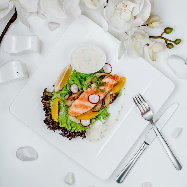 Free photo salmon salad with vegetables and white sauce