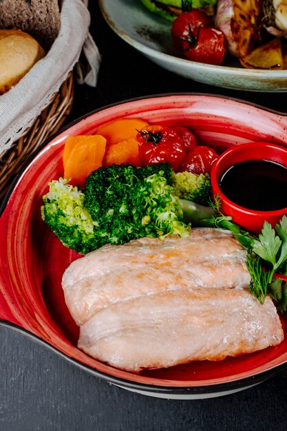 Salmon with broccoli carrot tomatoes and greens