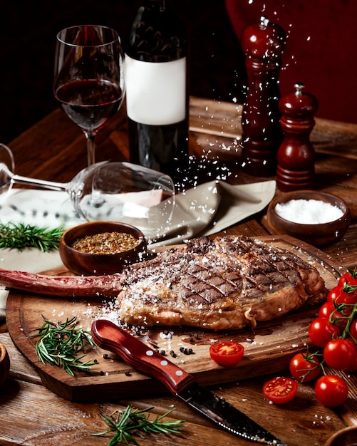 salt sprinkles are fallen on top of beef steak served with wine