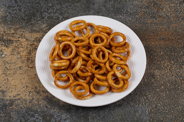 Salted circle pretzels on white plate.