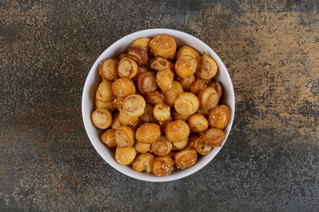 Salted tasty crackers in white bowl. 