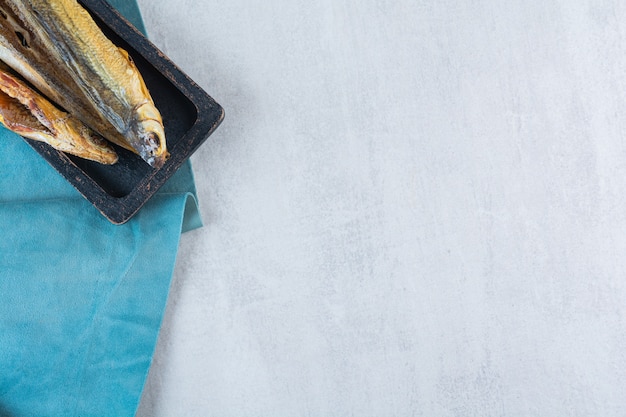 Free photo salty dried fish isolated on a wooden board