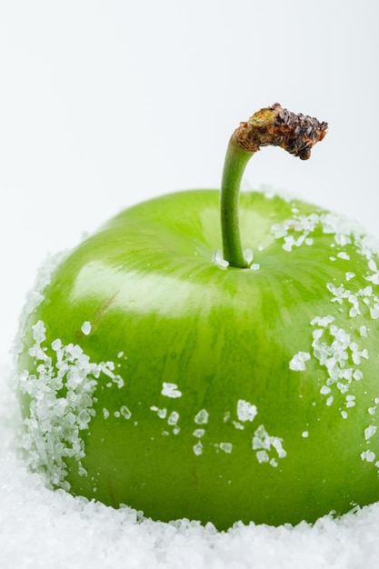 Free photo salty green plum on white wall, close-up.