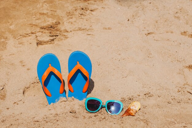 Sand with flip flops and seashells