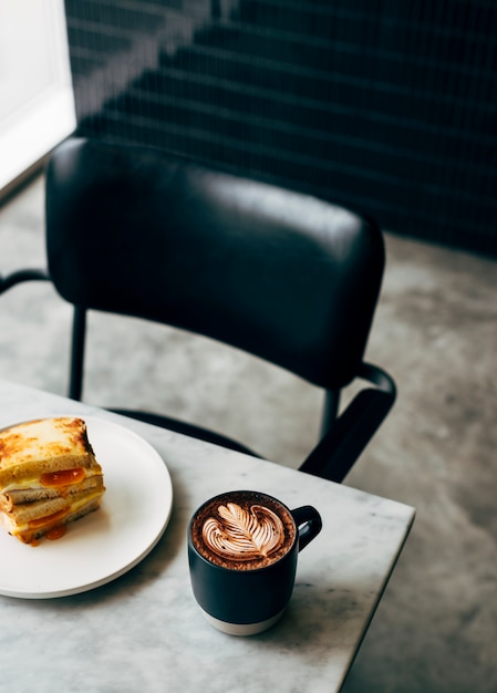 Free Photo sandwich and a cup of coffee on a table