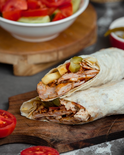 Sandwich in lavash on a wooden platter.