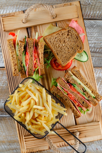 Sandwich with french fries top view on wooden tray