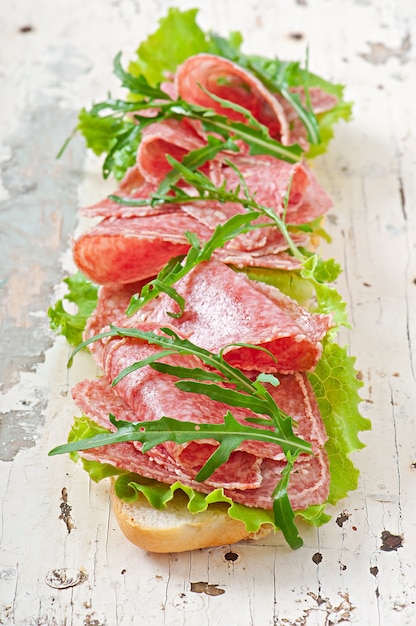 Free Photo sandwich with salami, lettuce, tomato and arugula