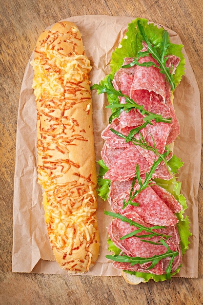 Sandwich with salami, lettuce, tomato and arugula