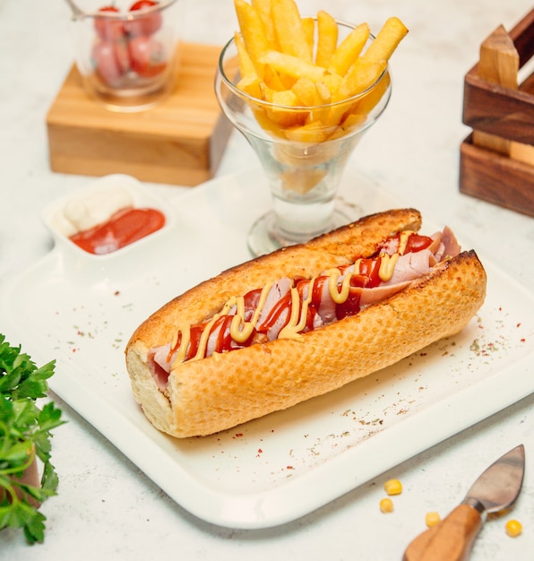 sandwich with sausage with sauce and french fries