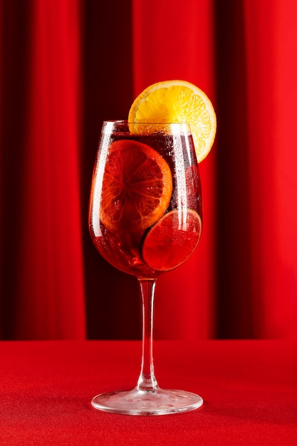 Free photo sangria drink with lemon slice on red background