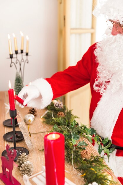 Santa Claus brightening New Year candles