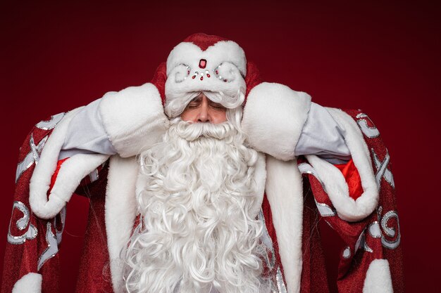 Santa Claus get tired and grabbed head for a headache, closed eyes