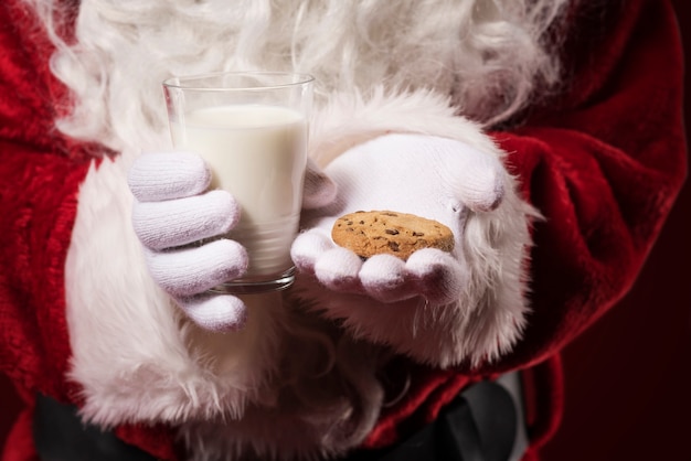 Santa Claus holding a cookie and a milk glass