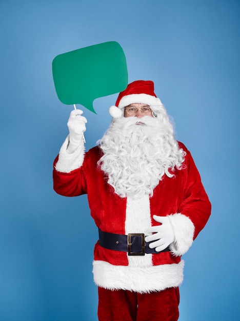 Free photo santa claus holding speech bubble at studio shot