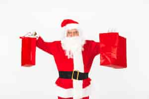 Free photo santa claus lifting christmas bags