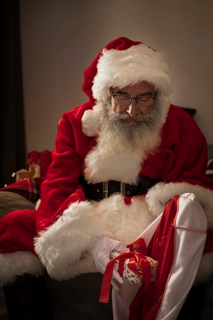 Free photo santa claus preparing his bag of gifts