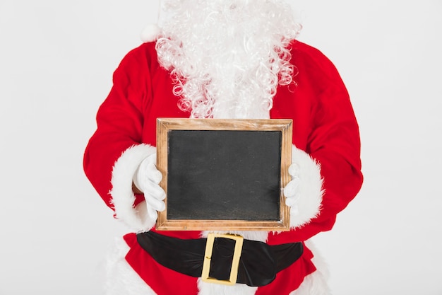 Free Photo santa claus showing empty wooden frame