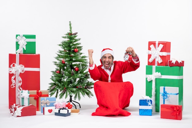 Santa claus sitting with gift boxes and tree