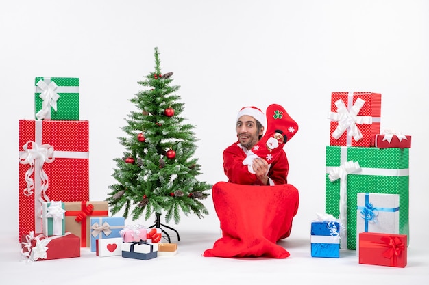 Santa claus sitting with gift boxes and tree