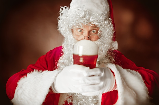 Free photo santa claus with a luxurious white beard, santa's hat and a red costume