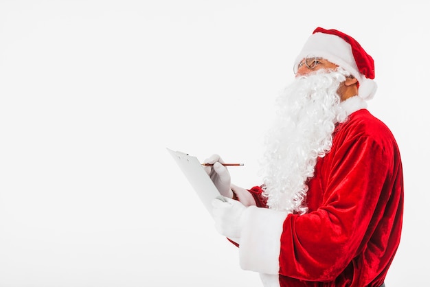 Free photo santa claus writing on clipboard