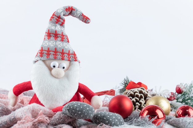 Santa figurine and festive baubles on white surface