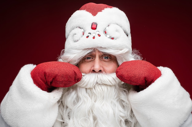 Free Photo santa gray haired senior male in mittens show his mustache