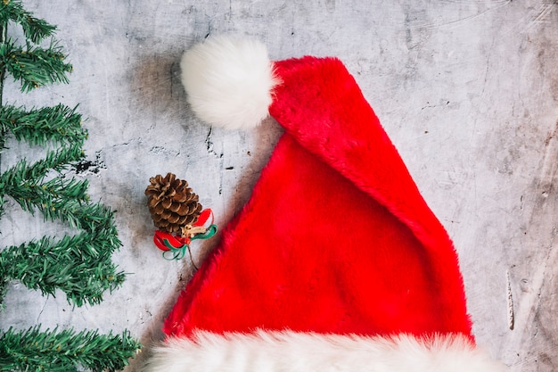 Free photo santa hat with fir tree branches on table