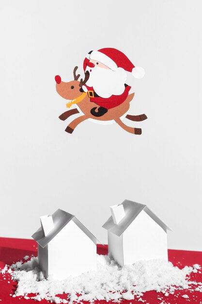 Santa and reindeer flying above houses