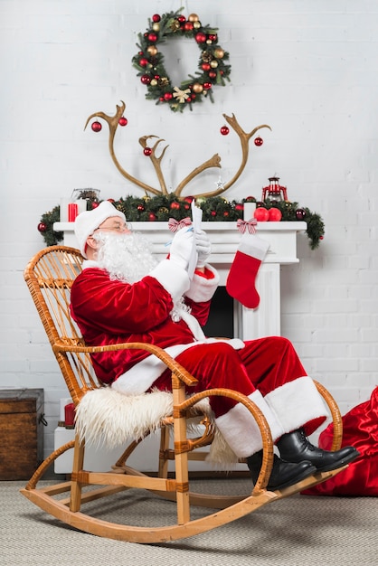 Free photo santa sitting in rocker with wishlist