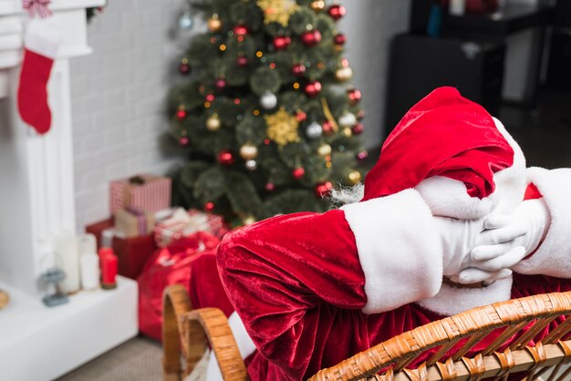 Free Photo santa sitting on rocking chair with hands behind head 