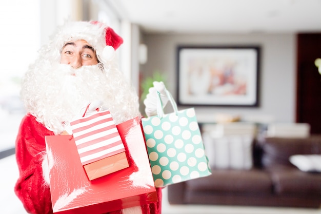 Free Photo santa with colored purchase bags in a house