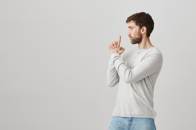 Sassy bearded man acting like secret agent with gun