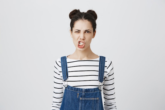 Free photo sassy young woman clench teeth, grimacing