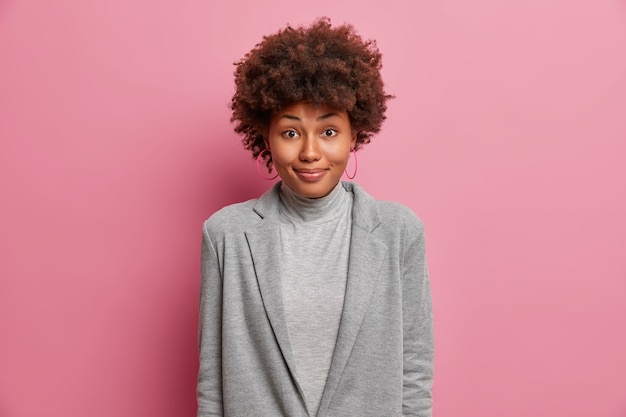 Free photo satisfied african american woman in grey formal clothes feels happy