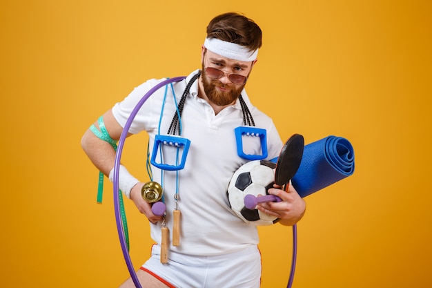 Free Photo satisfied bearded fitness man in sunglasses holding sports equipment