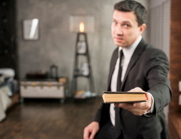 Free photo satisfied businessman offering book