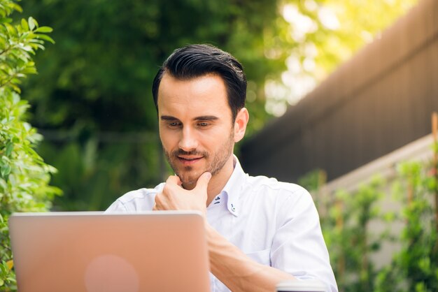 Satisfied businessman working on laptop with internet wireless