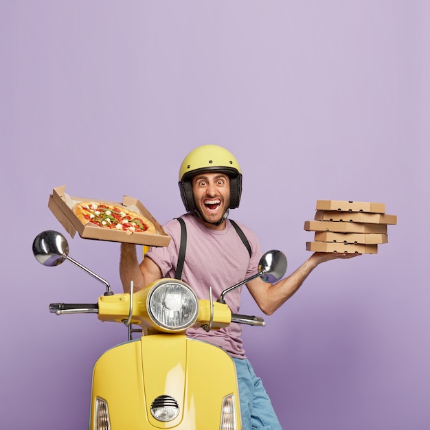 Free photo satisfied deliveryman driving yellow scooter while holding pizza boxes