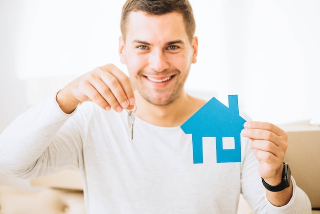 Free Photo satisfied man with keys and blue house