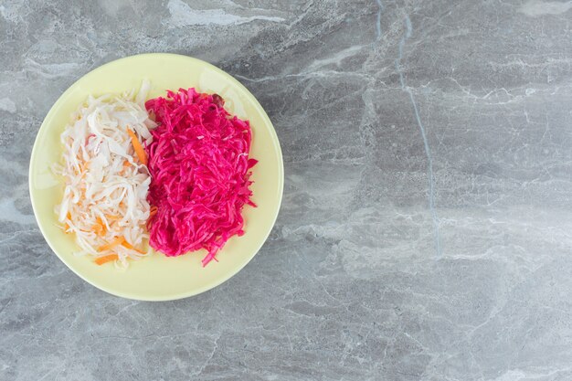 Sauerkraut on yellow plate . White and pink. 