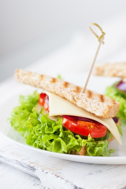 Sausage stuck on a stick with tomato and lettuce