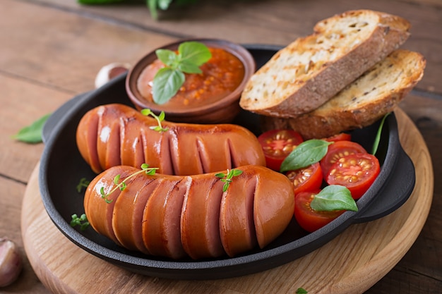 Sausages on the grill pan on the wooden table